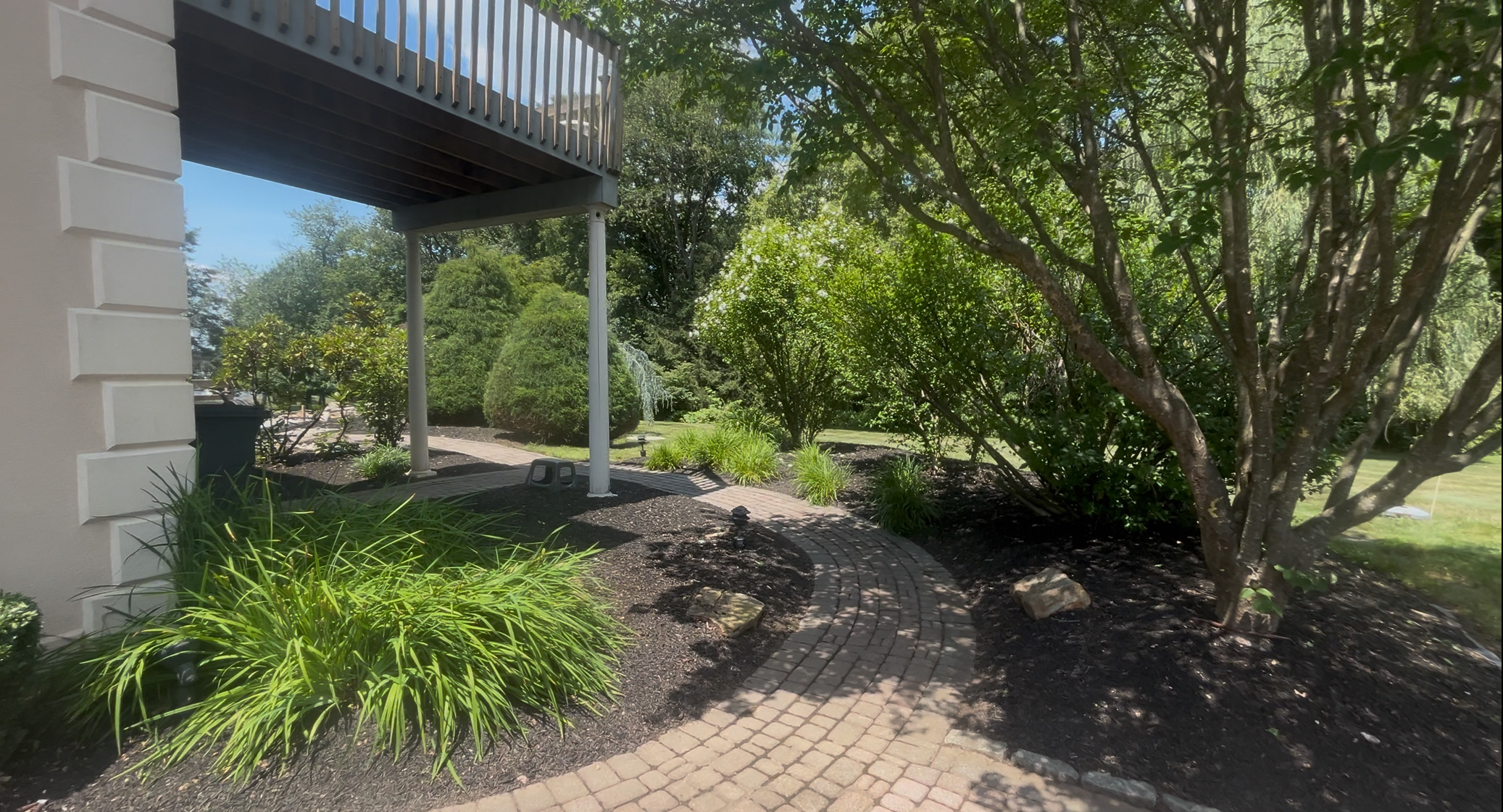 Professional landscaping with deck and walkway